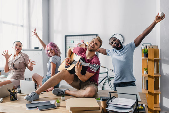  Multiethnic Business People Singing And Playing Acoustic Guitar In Office