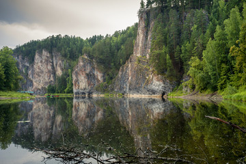 Fototapeta na wymiar An epic landscape of Ural nature on the Chusovaya river with large rocks along the river.