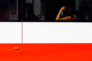 Ragazza con mascherina su autobus a Praga, bandiera tedesca