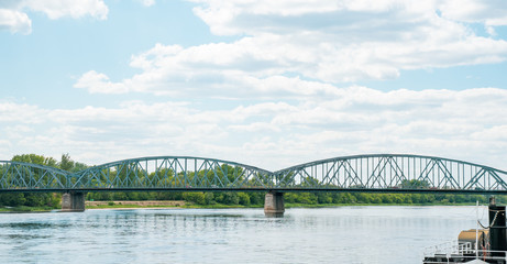 Photography road bridge over Vistula River in Torun (Pilsudski Bridge), Poland. Heavy rusty steel old industrial vehicle overpass. Landscape city view from boulevard.