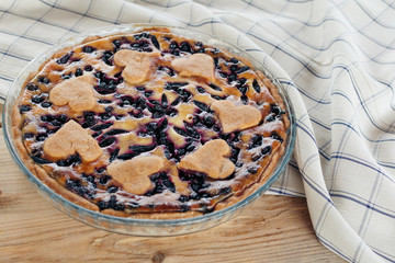 Honeysuckle pie on a wooden table with a checkered tablecloth.
