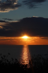 Fototapeta na wymiar Hunstanton beach sun set over the sea ,glowing deep orange ball of fire 