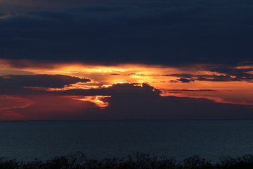 Hunstanton beach sun set over the sea ,glowing deep orange ball of fire 