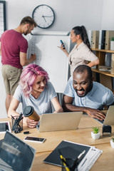 Selective focus of business people using laptops while working in office