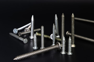 Screws and nails on a black background