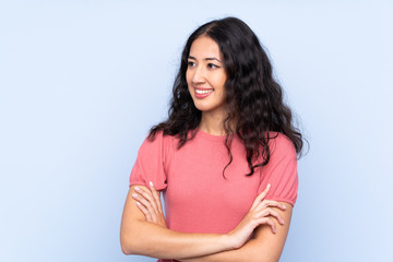 Fototapeta premium Mixed race woman wearing a sweater over isolated blue background looking to the side