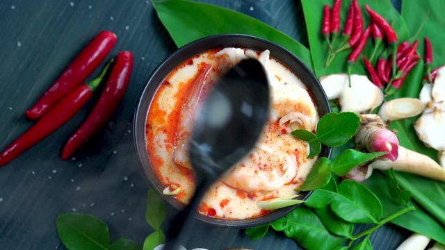 Tom Yum kung in a blow, spicy soup traditional Thai food cuisine, Tom Yam kung Spicy Thai soup with shrimp, seafood, coconut milk and herb.