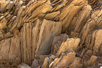 The stone rock is brown slate. Natural texture in natural light.