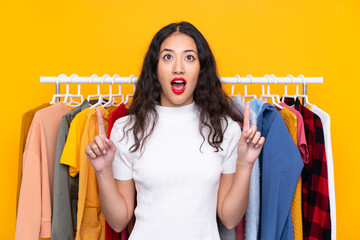 Mixed race woman in a clothing store pointing with the index finger a great idea