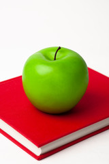 a green apple on a new book