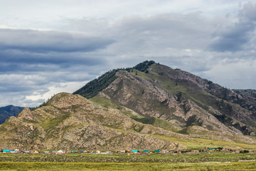 A small village with colorful houses is located at the foot of a large mountain.