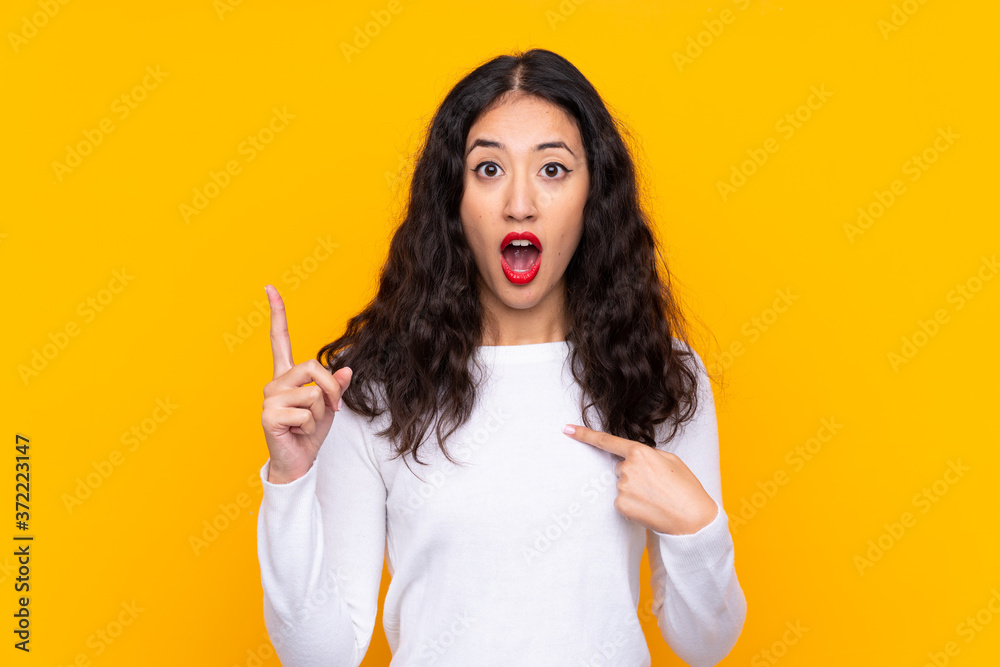 Sticker mixed race woman over isolated yellow background with surprise facial expression