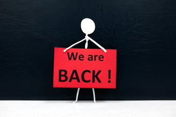 Stick man figure holding a We are Back red signage. Business and shop reopening after covid-19...