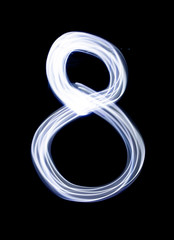 Number 8 eight, made with photo light painting technique isolated on black. Set of bright glowing numbers hand drawing with light