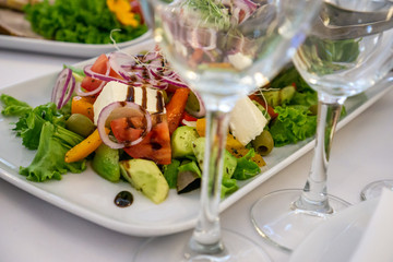Beautiful table setting in light colors with dishes and assorted food on a table with a white tablecloth for a party, wedding or other special event. Restaurant business and service industry concept.