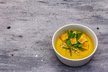 Yellow zucchini cream soup. Healthy vegan (vegetarian) food, crispy toast, sunflower seeds, fresh greens