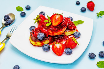 Cottage cheese pancakes with fresh berries and strawberry sauce. Healthy breakfast concept for kids
