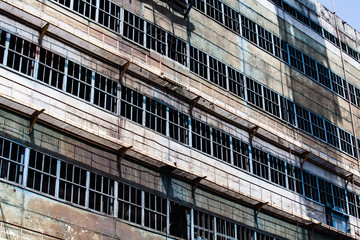 Old soviet abandoned metallurgy plant. Facade of industrial building with broken windows. Taraz...