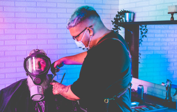 Hipster Senior Man Getting Haircut At Vintage Barber Shop - They Both Wear Face Protections Masks For Coronavirus Prevention - Focus On Gas Mask