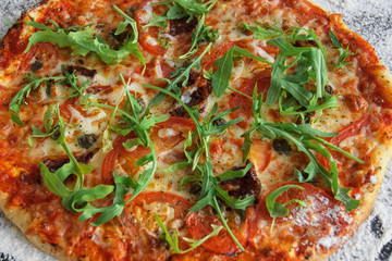 Pizza margarita with a crispy crust close-up. Arugula, lots of cheese. Delicious food.