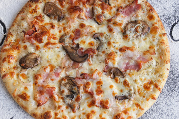 
Pizza with a crispy crust close-up. Mushrooms bacon, a lot of cheese. Delicious food.
