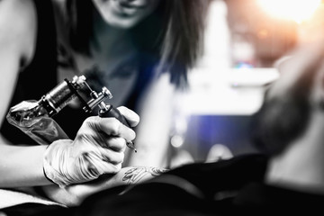 Professional Female Tattooist Working in a Tattoo Studio