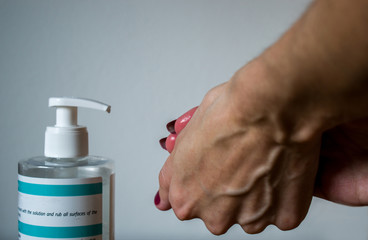 Close up of hands using alcohol gel as hand sanitizer