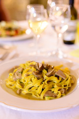Tasty homemade tagliatelle pasta with fresh harvested boletus porcini mushrooms in creamy sauce