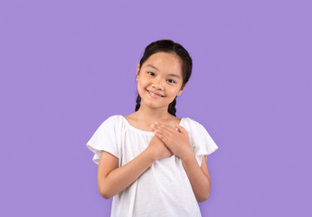 Thankful Chinese Girl Pressing Hands To Chest Over Purple Background