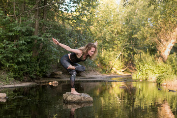 Young woman practicing breathing yoga pranayama outdoors in harmony with nature. Fitness girl doing...