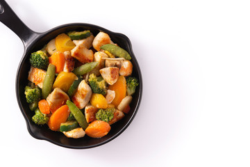 Stir fry chicken with vegetables on iron pan isolated on white background. Top view. Copy space