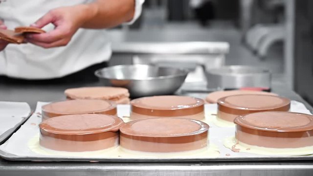 Pastry Chef making fresh delicious chocolate cakes at commercial kitchen. High quality FullHD footage