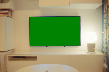 The TV is on the table, the green background on the TV.
