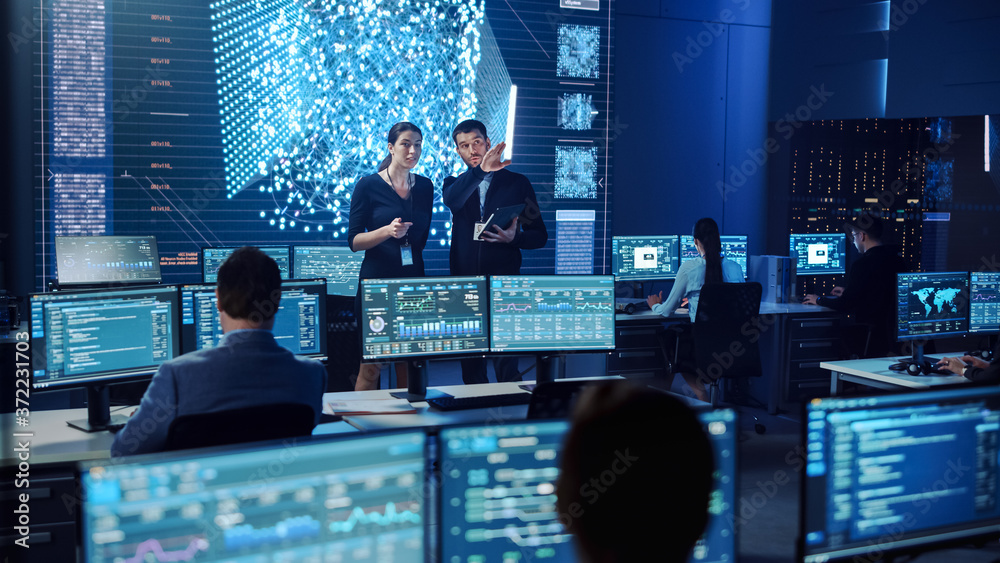 Poster Project Manager and Computer Science Engineer Talking while Using A Digital Tablet Computer. Telecommunications System Control Monitoring Room with Neural Network on Big Screen.