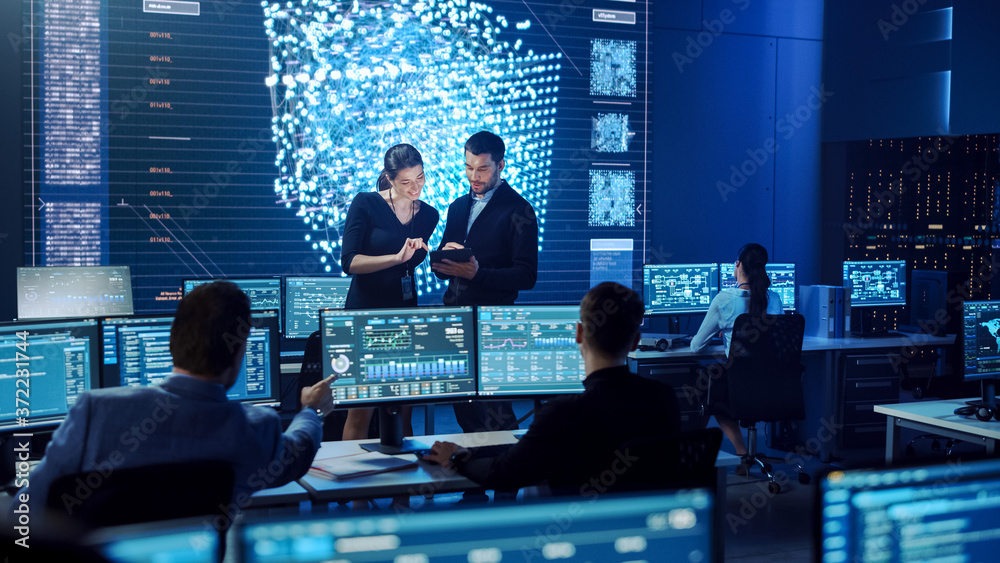 Poster Project Manager and Computer Science Engineer Talking while Using A Digital Tablet Computer. Telecommunications System Control Monitoring Room with Neural Network on Big Screen.