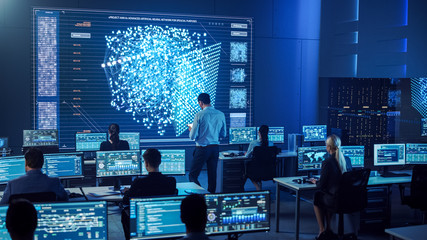 Team of Professional Computer Data Science Engineers Work on Desktops with Screens Showing Charts, Graphs, Infographics, Technical Neural Network Data and Statistics. Dark Control and Monitoring Room.