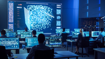 Team of Professional Computer Data Science Engineers Work on Desktops with Screens Showing Charts,...