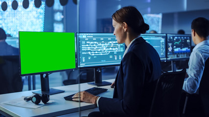 Confident Female Data Scientist Works on Personal Computer with Green Screen Mock Up in Big...