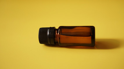 The bottle of cosmetic oil on the yellow background