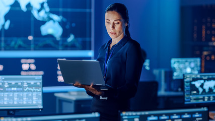 Female Project Leader is Standing with Laptop Computer and Checking Work Data. Science Engineers...