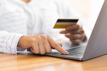 Woman using pc and credit card at home