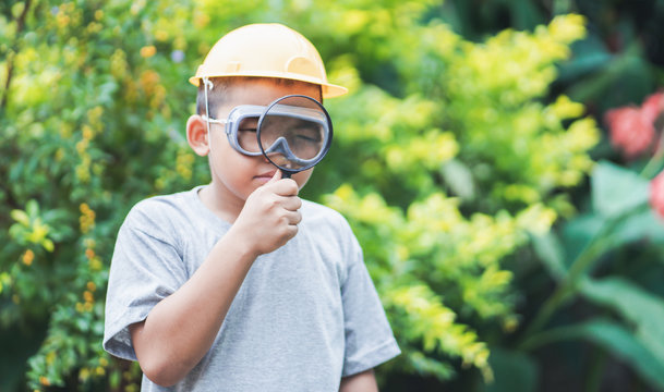 Asian Kid Holding Magnifying Glass Playing Outdoors.