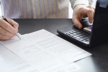 Manager works at a laptop in the office. Businessman makes an online transaction. Trading on the exchange via the Internet.