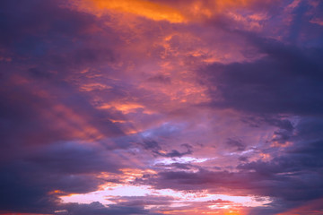 Naklejka na ściany i meble Sunset in the clouds. Blue orange purple sunset background. A bright beautiful sunset on a dramatic sky. Cloudscape. Evening thunderstorm.
