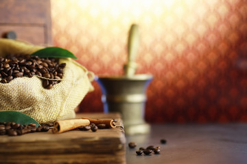 Bag of coffee. Coffee beans roasted on the table. Coffee beans with green leaves for cooking.