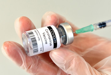 COVID-19 vaccine vial, bottle in hand.at Pfizer laboratory