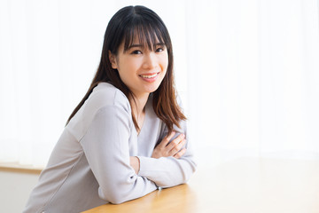 部屋の窓際に座る若い女性