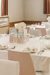 Pastel pink-white elegant wedding decoration with flowers, mirror, decorated table for celebration.