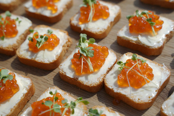 canapes with red caviar and young sprouts of greenery