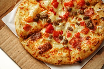 Pizza, close up photo of a delicious pizza with mozzarella cheese, onions, meat, tomato.